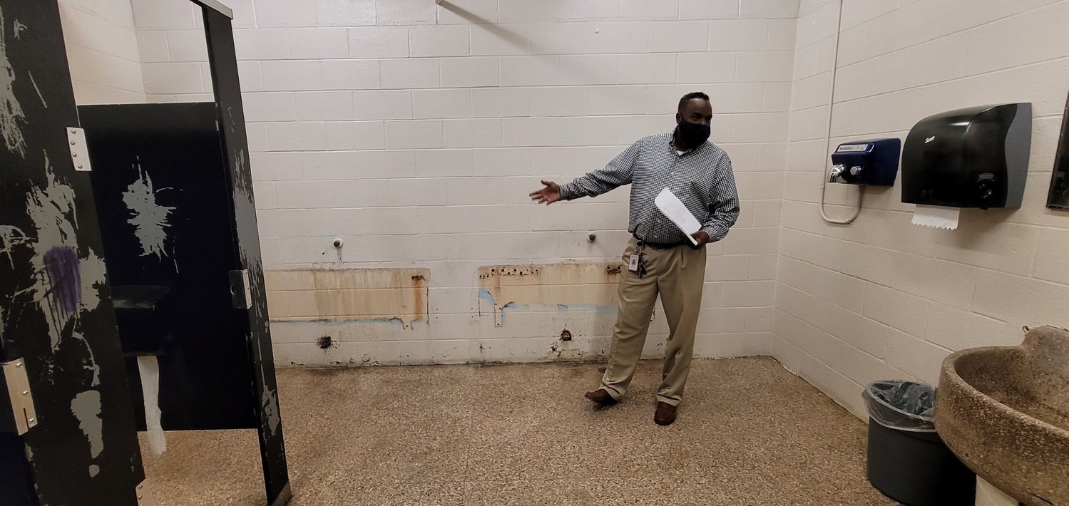 RISD Operations Director Derrick Dabney shows where urinals are missing from the walls in the boys’ bathroom and Royal Junior High School. Collapsed drainpipes in the walls and under the floor have prevented the installation of new urinals – one of many serious maintenance issues at the half-century-old campus.